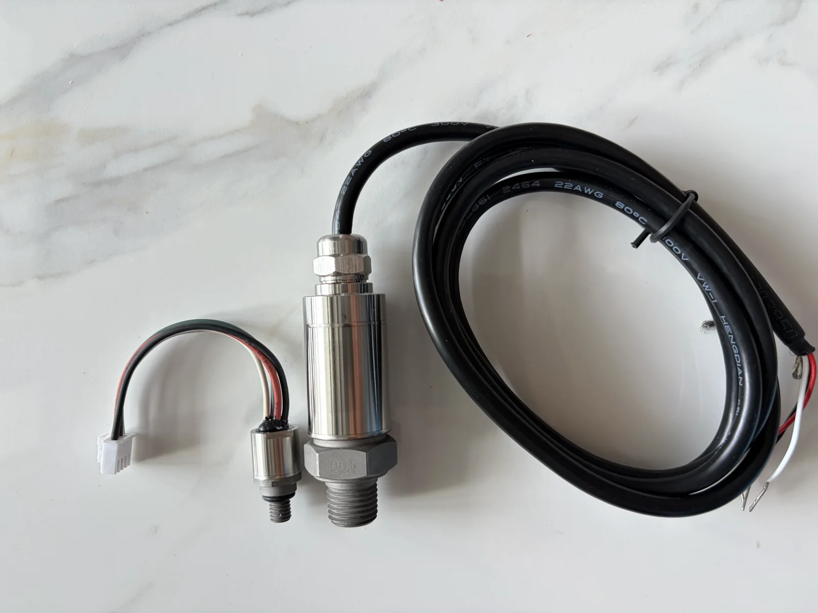 Package-size reference: a compact pressure/temperature sensor platform at left and the FQ3100 standard industrial transducer at center.